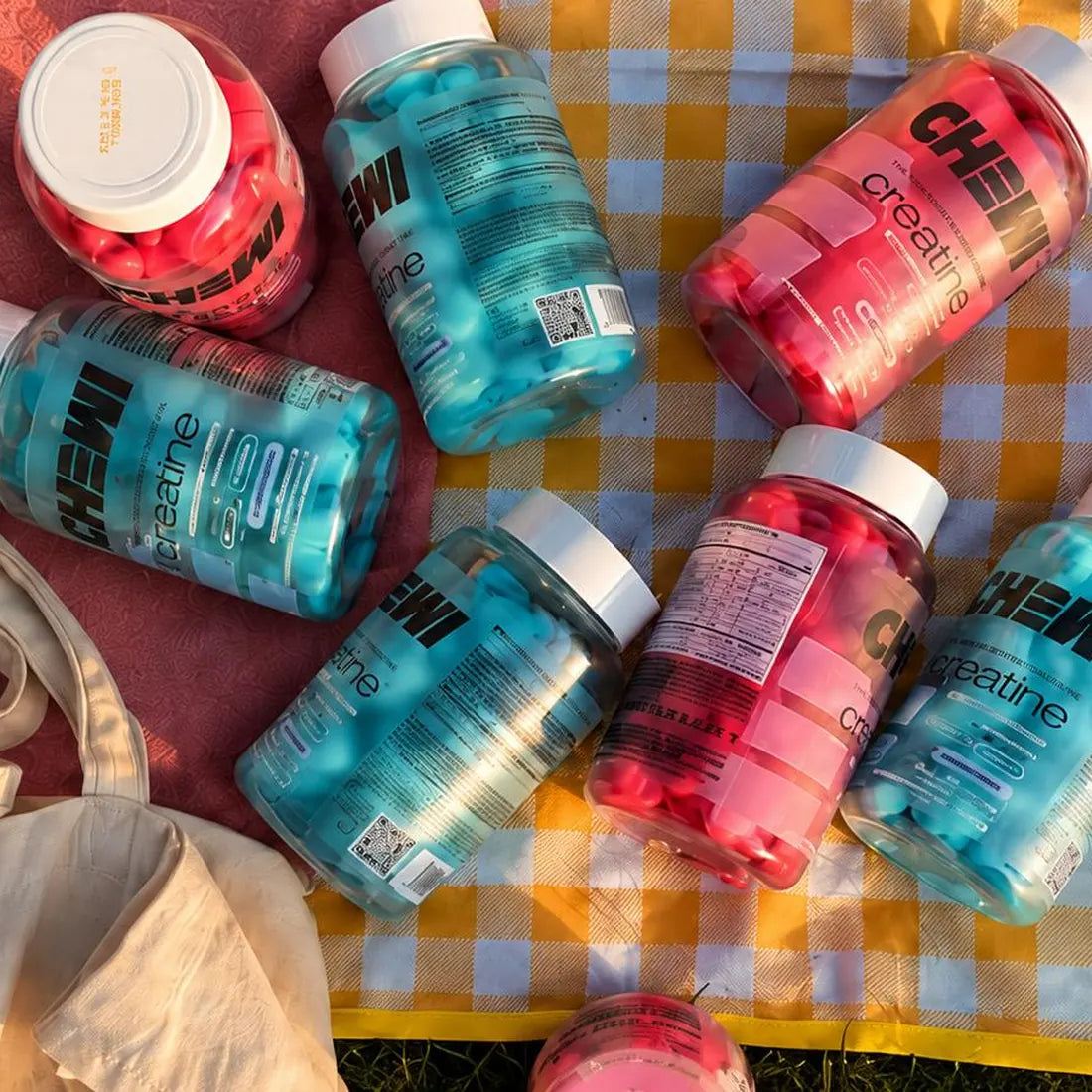 Jars of Chewi Red Berry Mix and Blue Raspberry on a picnic blanket